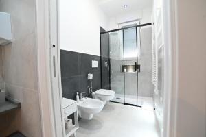 a bathroom with a toilet and a glass shower at Brindisi Airport Rooms in Brindisi