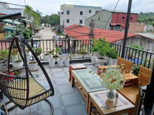 a balcony with tables and potted plants on it at Nhà nghỉ Homestay Minh Hạnh in Nà Phia