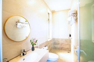 ein Badezimmer mit Waschbecken, Toilette und Spiegel in der Unterkunft May The Hotel in Cần Thơ + 67 Fotos