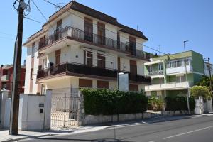 a white building with balconies on the side of a street at Brindisi Airport Rooms in Brindisi