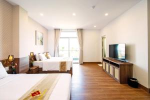 ein Hotelzimmer mit zwei Betten und einem Flachbildfernseher in der Unterkunft May The Hotel in Cần Thơ