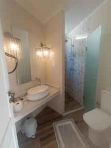 a bathroom with a sink and a toilet and a mirror at Korina Studios in Paleokastritsa +67 photos