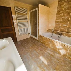 a bathroom with a tub and a sink at Le Clos des Argillières in Le Perrey +24 photos