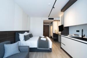 a hotel room with a bed and a kitchen at Sunset Premium in Keramoti