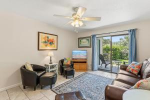a living room with a couch and chairs and a ceiling fan at Sea Woods 115 in New Smyrna Beach