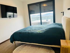a bed in a room with a large window at L'évasion in Corent