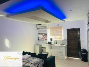 a blue ceiling in a living room with a kitchen at Fourways Executive Residence in Four Ways
