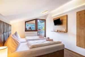 a bedroom with a large white bed with a window at Apartment - Ferienwohnung Elisabeth in Radstadt