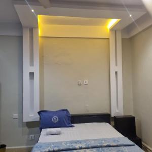 a room with a bed with a blue pillow on it at GLAMOSSAY HOTEL LIMITED SUNYANi in Abesem +11 photos