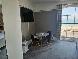 a room with a table and chairs and a window at Waterfront Hotel in Deal