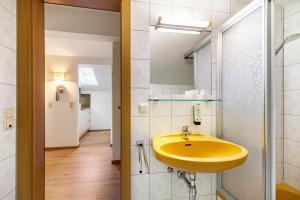 a bathroom with a yellow sink and a hallway at Apartment - Ferienwohnung Elisabeth in Radstadt +22 photos
