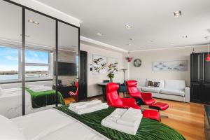 a bedroom with red chairs and a living room at Diamond Suites by Reykjavik Keflavik Airport in Keflavík