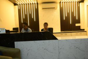 two people sitting at a desk in an office at Hotel O Westin Regency in Monber +21 photos