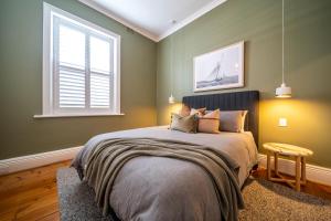 a bedroom with a bed and a window at Wisteria Cottage circa 1880 in North Adelaide