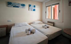 two beds in a room with towels on them at Luisa in Malgrat de Mar +29 photos