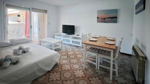 a living room with a bed and a table and a dining room at Luisa in Malgrat de Mar