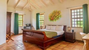 a bedroom with a bed in a room with windows at Quill Gardens Boutique Hotel in Oranjestad +78 photos