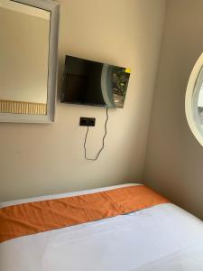 a room with a bed and a tv on the wall at Sera INN Cikarang in Jatirarangan