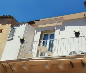 a balcony of a house with a table and chairs at La Chicca nel Barocco - Modica Centro - Indipendente in Modica