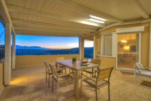 a dining room with a table and chairs on a balcony at Nautilus Villa - Private Pool in Elaía