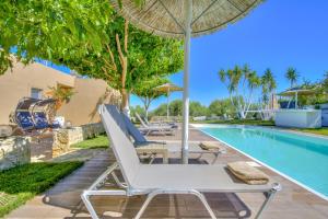 a pool with two lounge chairs and an umbrella at Nautilus Villa - Private Pool in Elaía