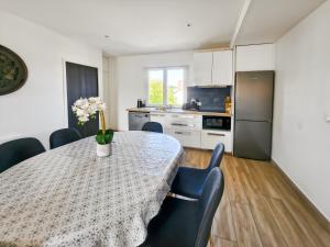 a kitchen with a table and chairs and a kitchen with a refrigerator at L'atelier Lena, Calme, Confort, 10 min Disneyland in Montry