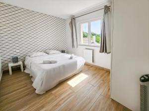 a white bedroom with two beds and a window at L'atelier Lena, Calme, Confort, 10 min Disneyland in Montry