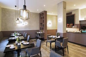 a restaurant with tables and chairs and a kitchen at Hotel Stadt Tuttlingen in Tuttlingen
