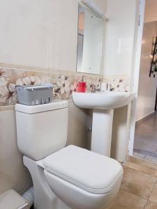 a white bathroom with a toilet and a sink at The palace001 in Mombasa +23 photos