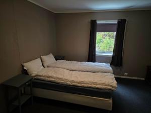 a bed in a room with a window at Leilighet ved vannet in Konsmo
