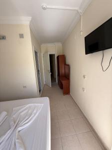 a bedroom with a bed and a flat screen tv at Holiday Hotel in Erdemli +11 photos
