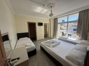 a hotel room with two beds and a window at Holiday Hotel in Erdemli