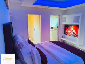 a bedroom with a bed with a fire in the fireplace at Fourways Executive Residence in Four Ways