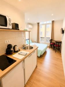 a hotel room with a kitchen and a bed at Résidence Appartement Adonis in Nice