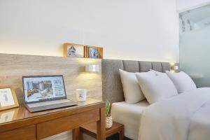 a bedroom with a laptop on a desk next to a bed at Hotel Z in Taichung