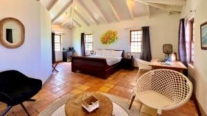 a living room with a bed and a table and chairs at Quill Gardens Boutique Hotel in Oranjestad