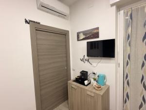 a bathroom with a door and a television on the wall at B&B Nonno Walter in Torre del Greco