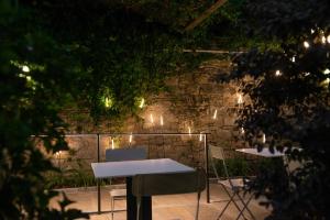 a patio with tables and chairs and a brick wall with lights at Le Funi Hotel in Bergamo