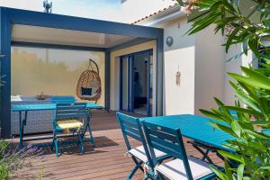 a patio with blue tables and chairs on a deck at Chambres D'hôtes Authentique Pornic in Pornic