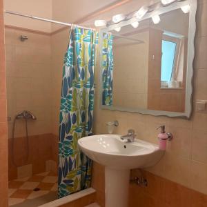 a bathroom with a sink and a shower curtain at Dais Apartments in Mitika +55 photos