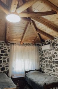 a attic room with a bed and a stone wall at VEIS Country House in Kamenicë