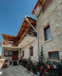 a stone house with flowers in front of it at VEIS Country House in Kamenicë
