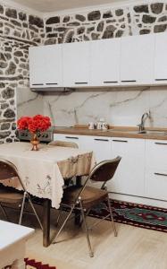 a kitchen with a table with a vase of flowers on it at VEIS Country House in Kamenicë