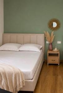 a bed in a bedroom with a mirror on the wall at Melody's Room in Borsh