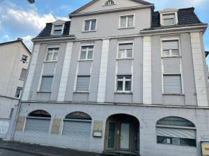 a large white building with a door on a street at Schöne Ferien- und Monteurwohnung in Ennepetal