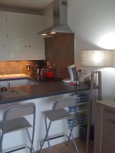 a kitchen with two bar stools and a counter top at Appart avec terrasse proche mer in Macinaggio +19 photos