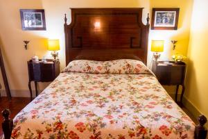 a bedroom with a bed with a floral bedspread at Quinta de S.Vicente in Geraz do Minho