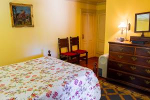 a bedroom with a bed and a dresser and two chairs at Quinta de S.Vicente in Geraz do Minho