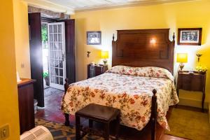 a bedroom with a bed with a floral bedspread at Quinta de S.Vicente in Geraz do Minho