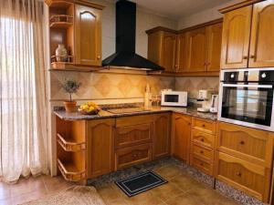 a kitchen with wooden cabinets and a stove top oven at Casa Centro 48 by Eden Mar - Ideal para estancias temporales in Guardamar del Segura